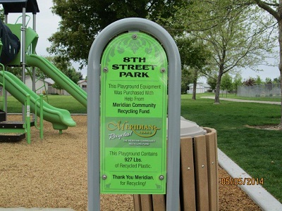 green sign in front of playground equipment