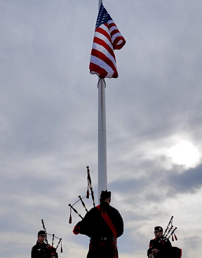 Pipes and Drums performers under an American flag at Kleiner park