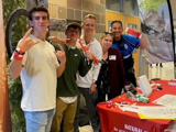 Students working an education booth at school.