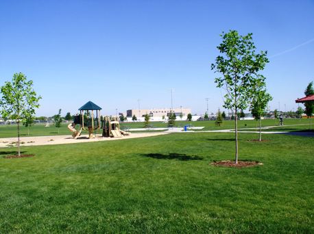 grassy field and playground at Gordon Harris Park