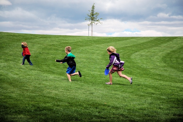children running in grass at Julius M. Kleiner Memorial Park