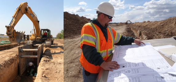 backhoe at a construction site; construction worker reviewing documents