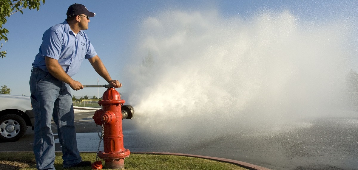 man flushing water from water hydrant
