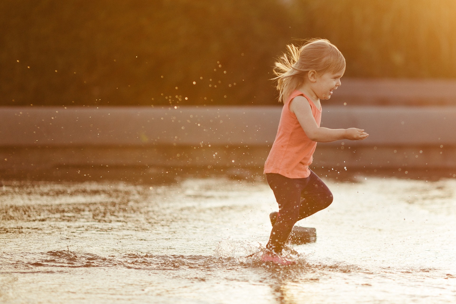 toddler playing in water at splash pad